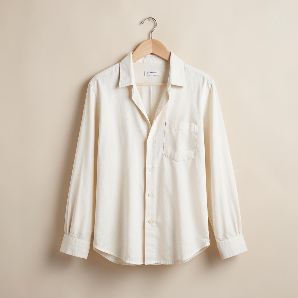 Chemise Open Collar écrue sur cintre devant un fond beige clair