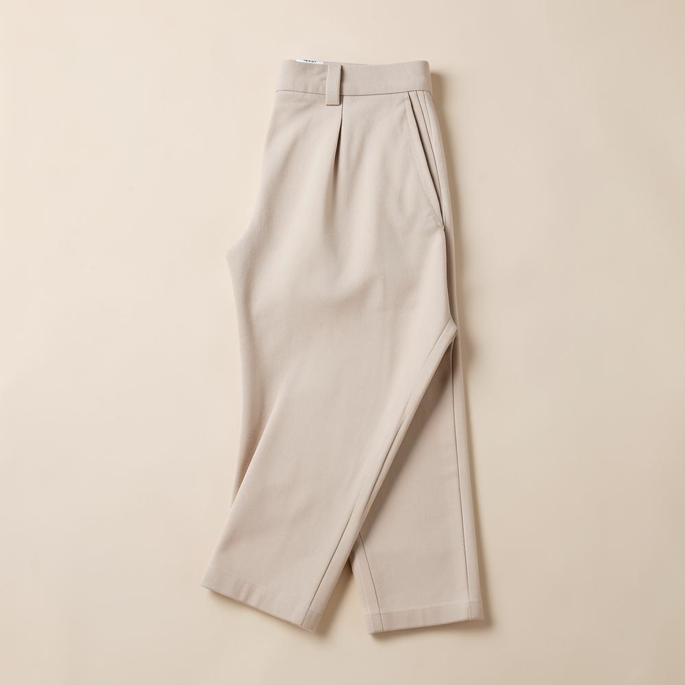 Pantalon Urban Flex couleur sable plié sur fond beige clair